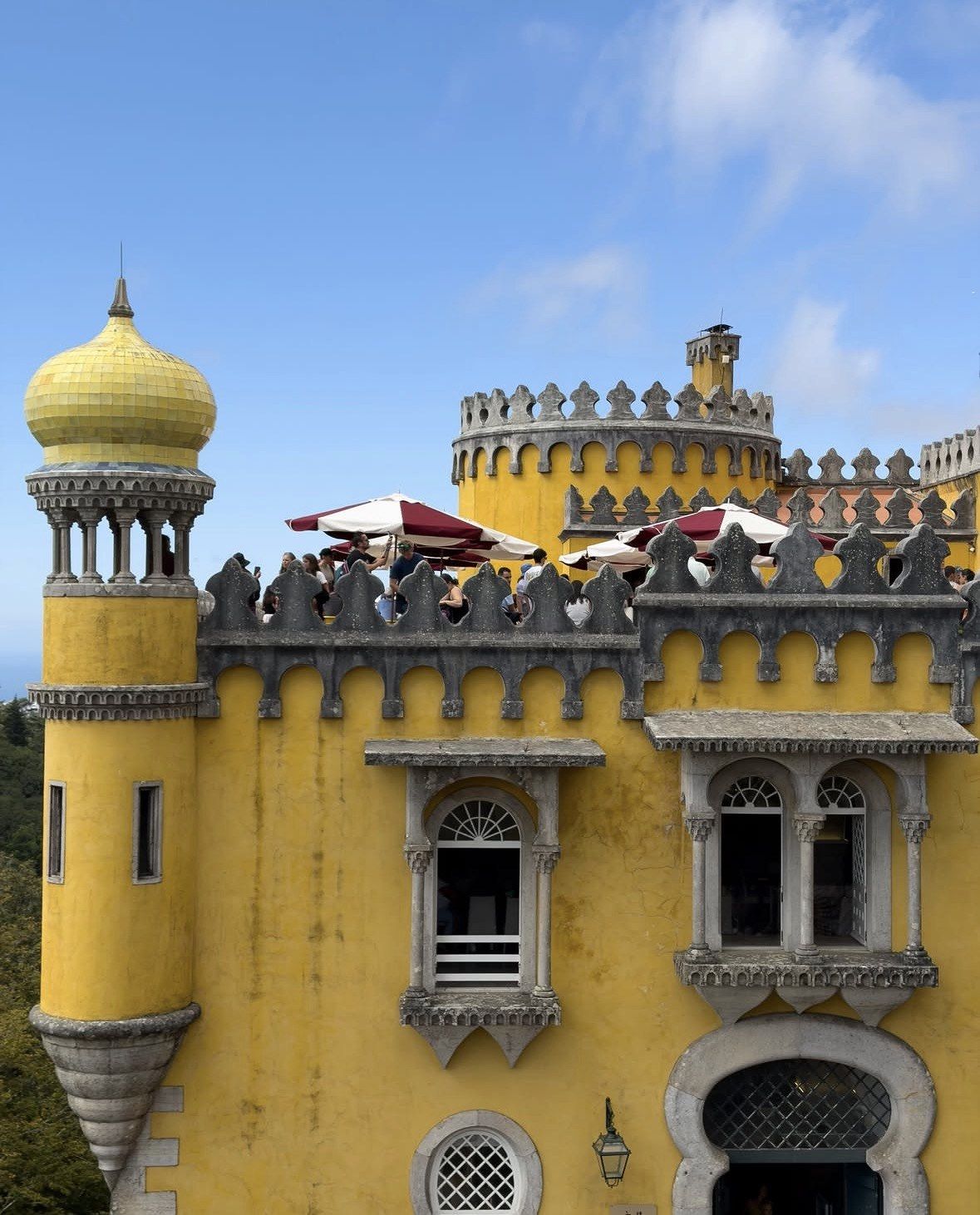 Golden onion dome and parasols on a crowded Pena Palace terrace