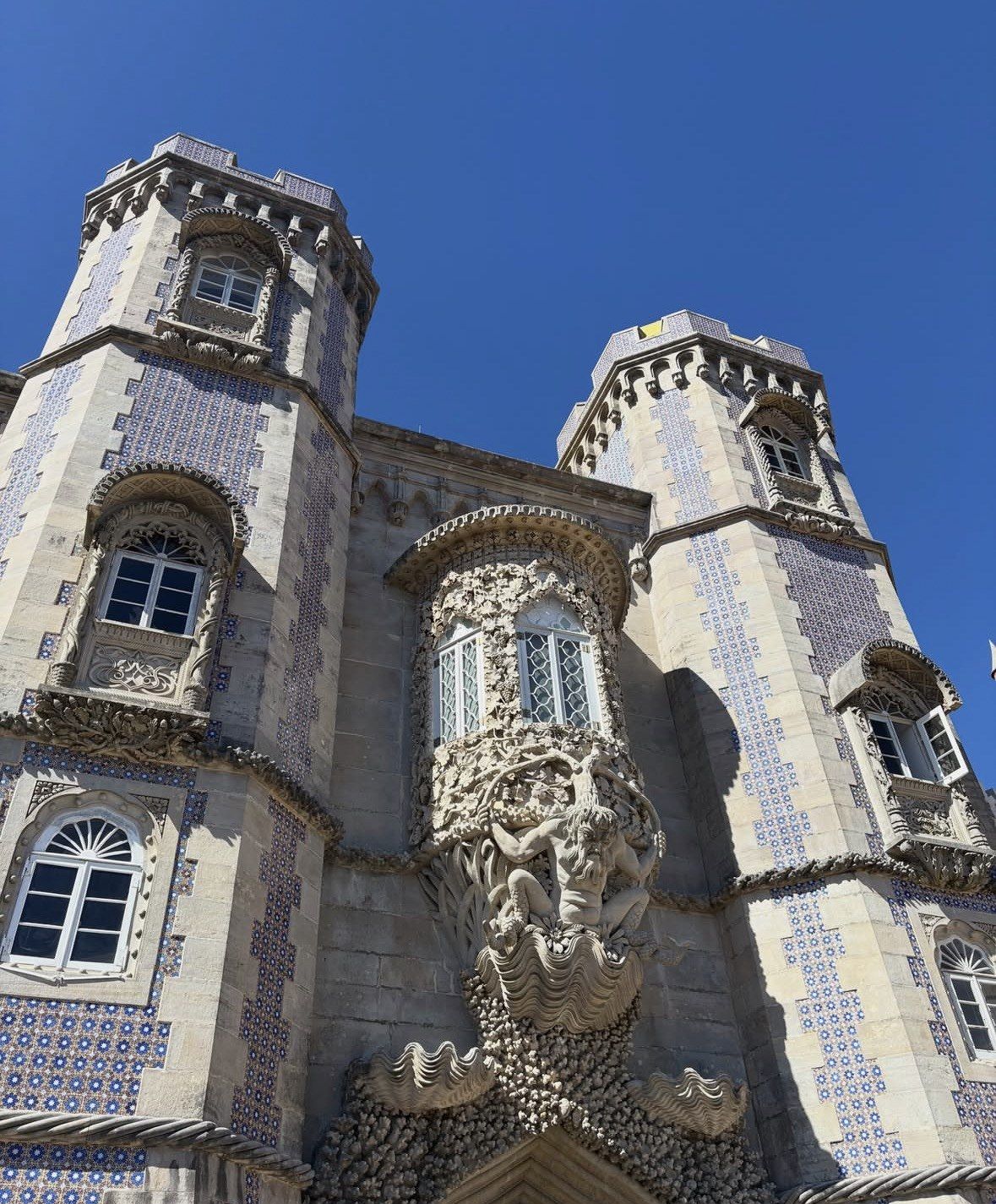 Shell and coral carvings framing a window between tiled Pena Palace towers