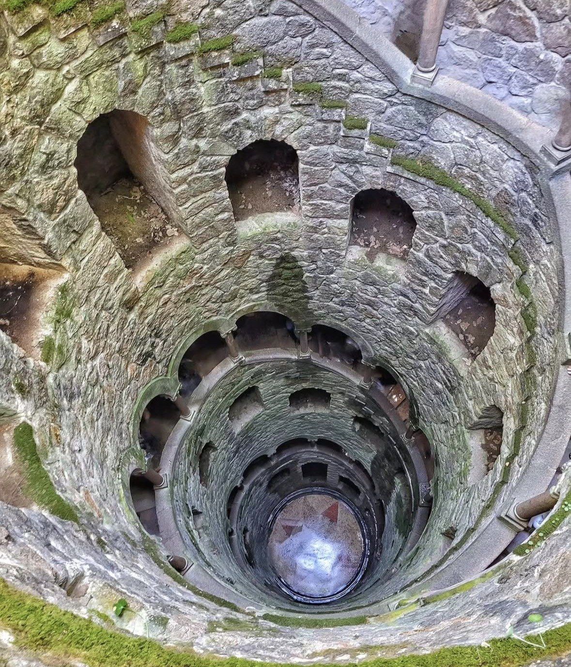Spiral staircase of the mossy Initiation Well viewed from the top