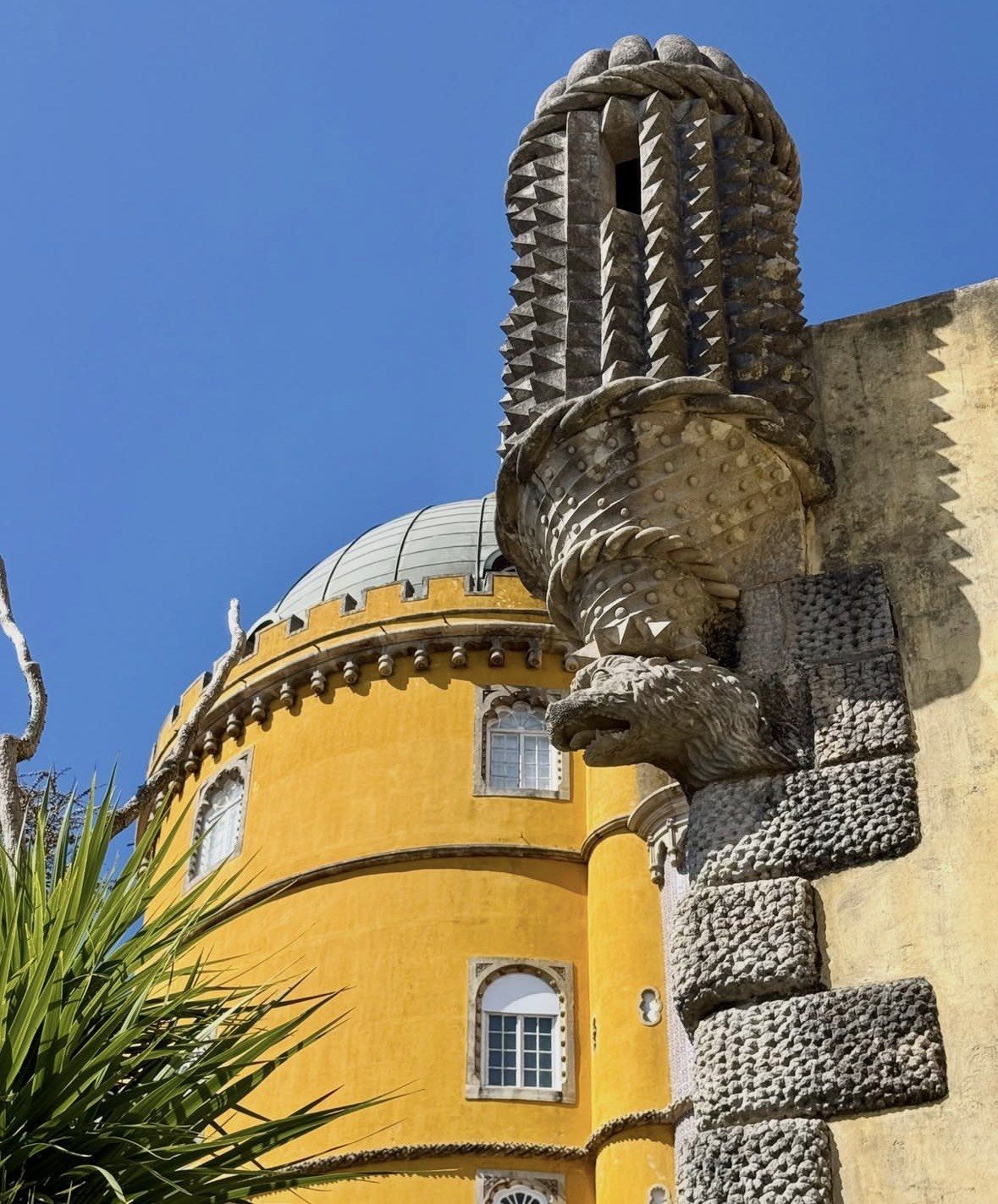 Spiked stone turret beside the yellow rotunda dome of Pena Palace