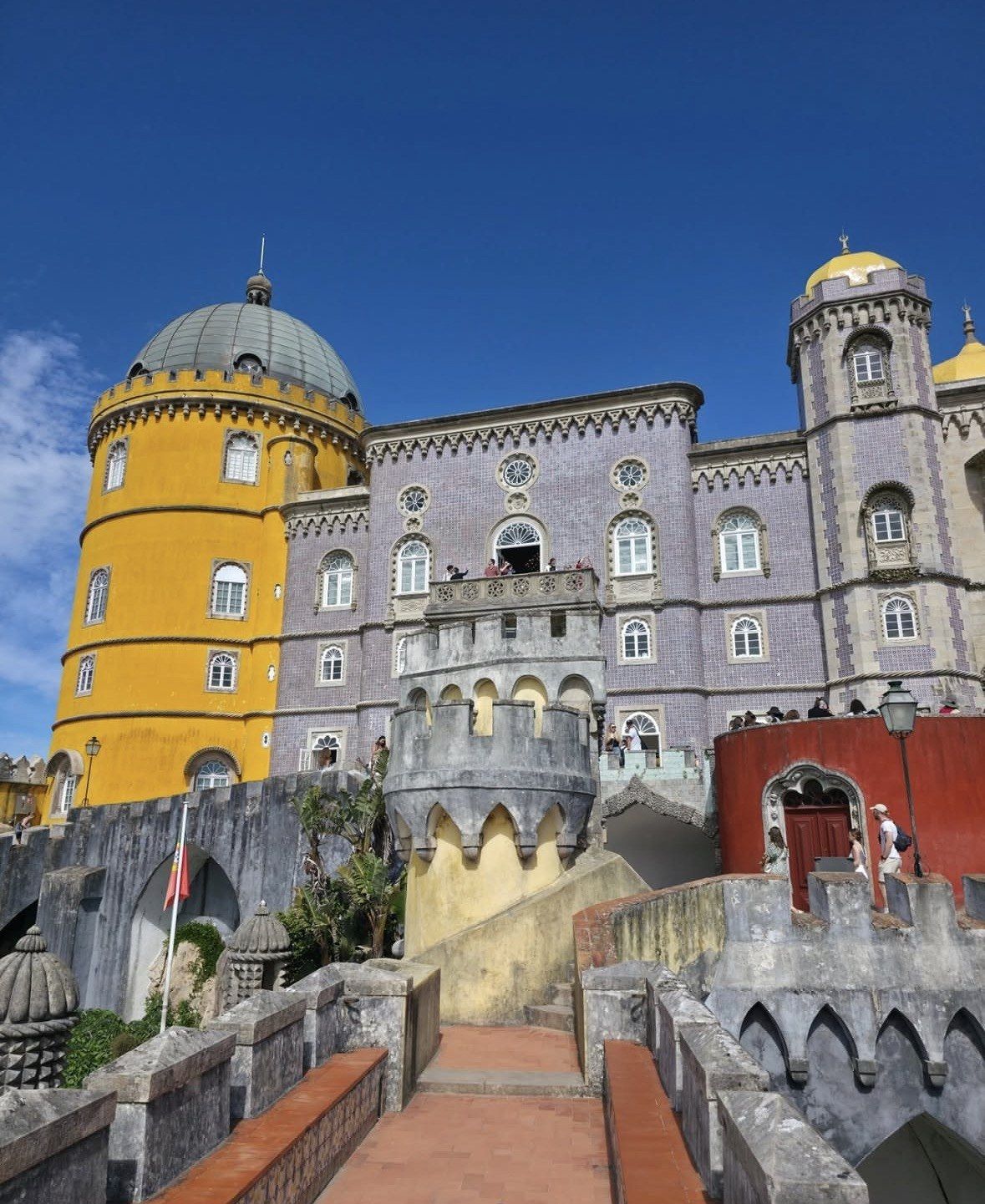 Violet tiled facade and yellow rotunda of Pena Palace in sunshine