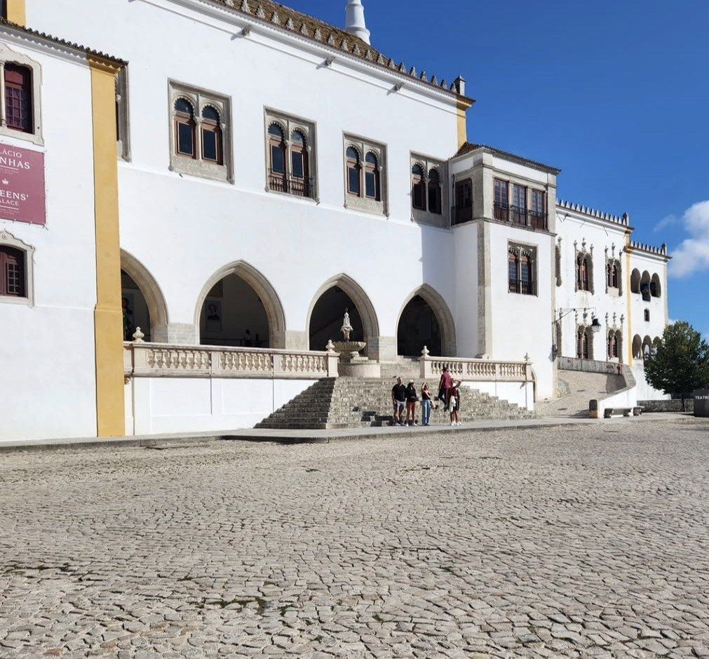 Whitewashed arcades of Sintra National Palace above a cobbled square